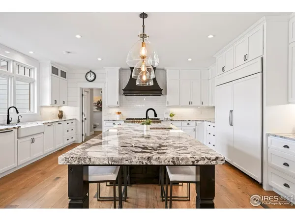 a view of kitchen center island wooden floor cabinets and stainless steel appliances