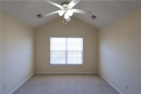 an empty room with a window and a fan