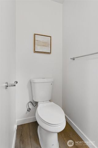 a white toilet sitting next to a wooden cabinet