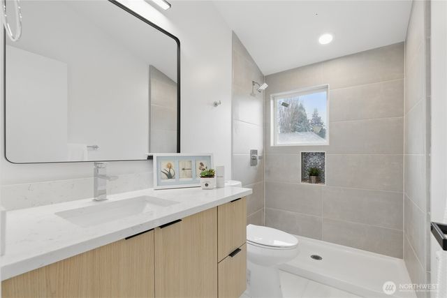 a bathroom with a sink a toilet a shower and a mirror