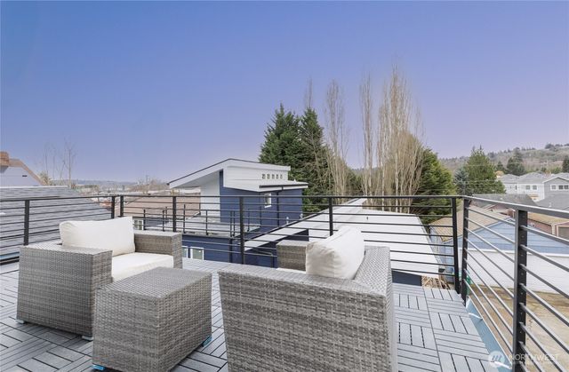 a view of a roof deck with couches and sky view