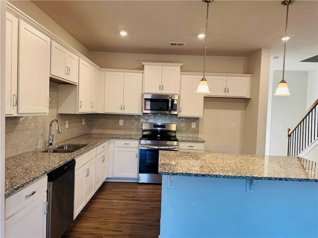 217 Dupont Drive Cartersville, GA 30121 - Photo 2 of 7 a large kitchen with stainless steel appliances granite countertop a stove a sink and a white cabinets