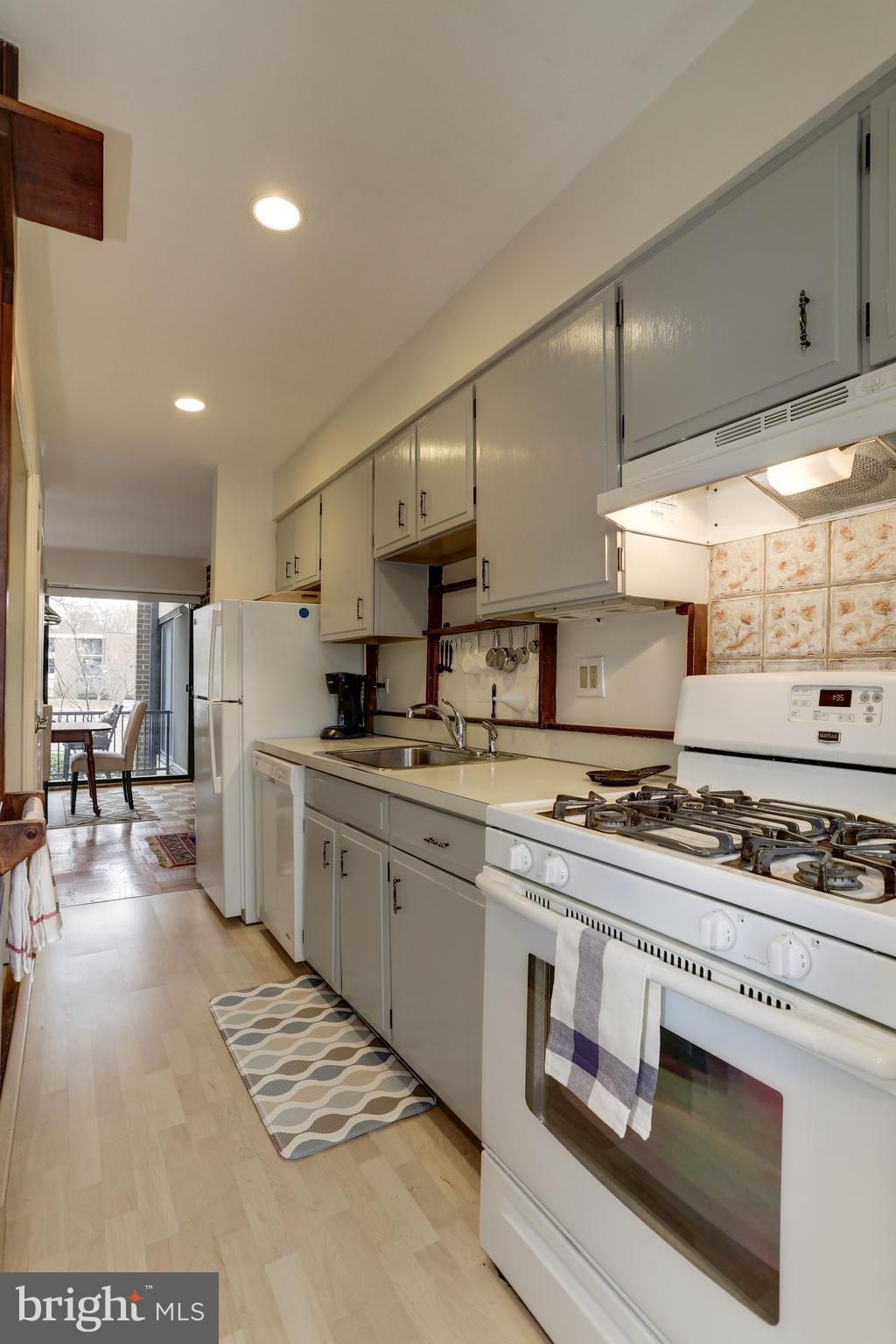 2016 Coleridge Drive, Unit 202 Silver Spring, MD 20902 - Photo 10 of 30 GALLEY KITCHEN WITH LAMINATE FLOOR AND GAS RANGE