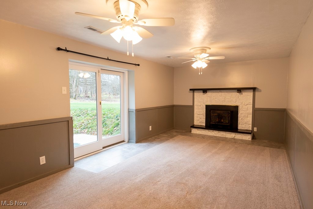 11819 Sheldon Road Mantua, OH 44255 - Photo 25 of 46 Unfurnished family room with ceiling fan, a wood burning fireplace, light carpet, and a textured ceiling