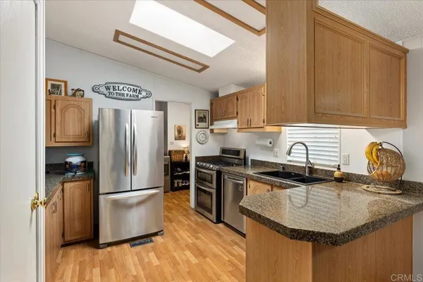 a kitchen with stainless steel appliances granite countertop a sink stove and refrigerator