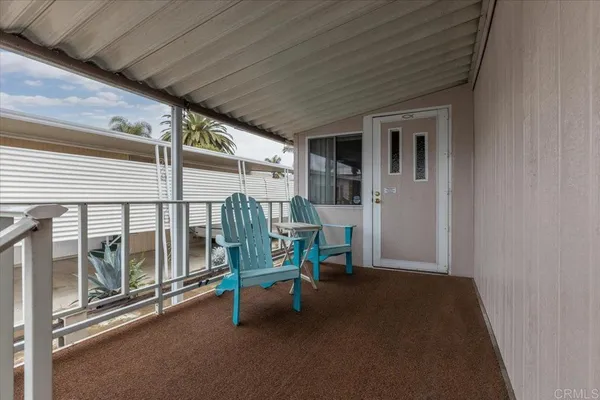 a view of a balcony and dining room with furniture wooden floor and garden view
