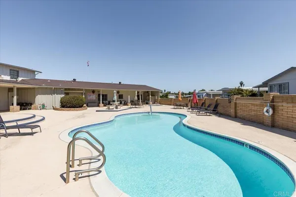 a swimming pool with outdoor seating and yard