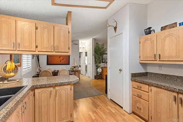a kitchen with granite countertop a sink a stove and cabinets