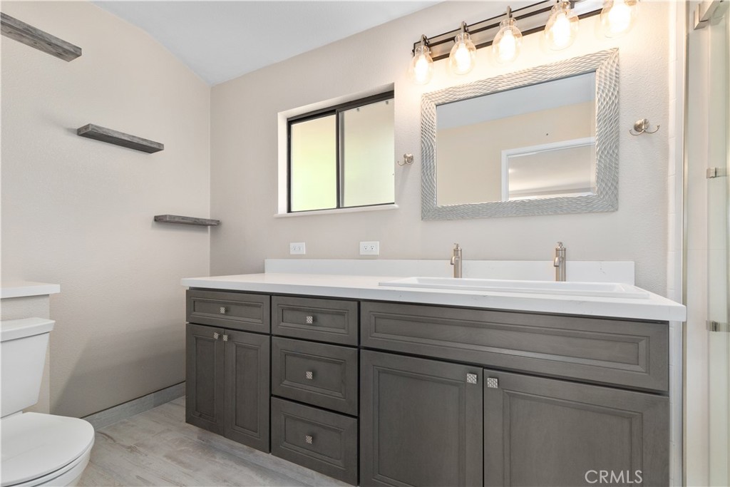 14220 El Monte Road Atascadero, CA 93422 - Photo 41 of 61 a bathroom with a toilet a sink a vanity and mirror