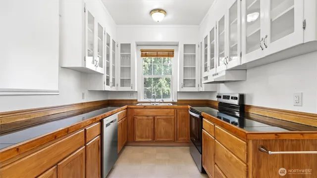 a kitchen with stainless steel appliances granite countertop a sink stove and cabinets
