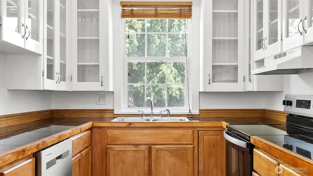 a kitchen with granite countertop a refrigerator and a sink