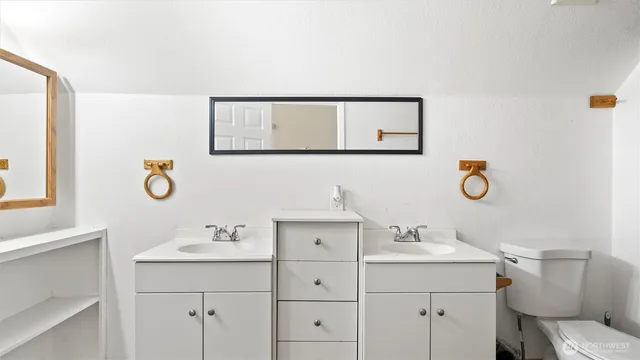 a bathroom with a sink mirror vanity and toilet