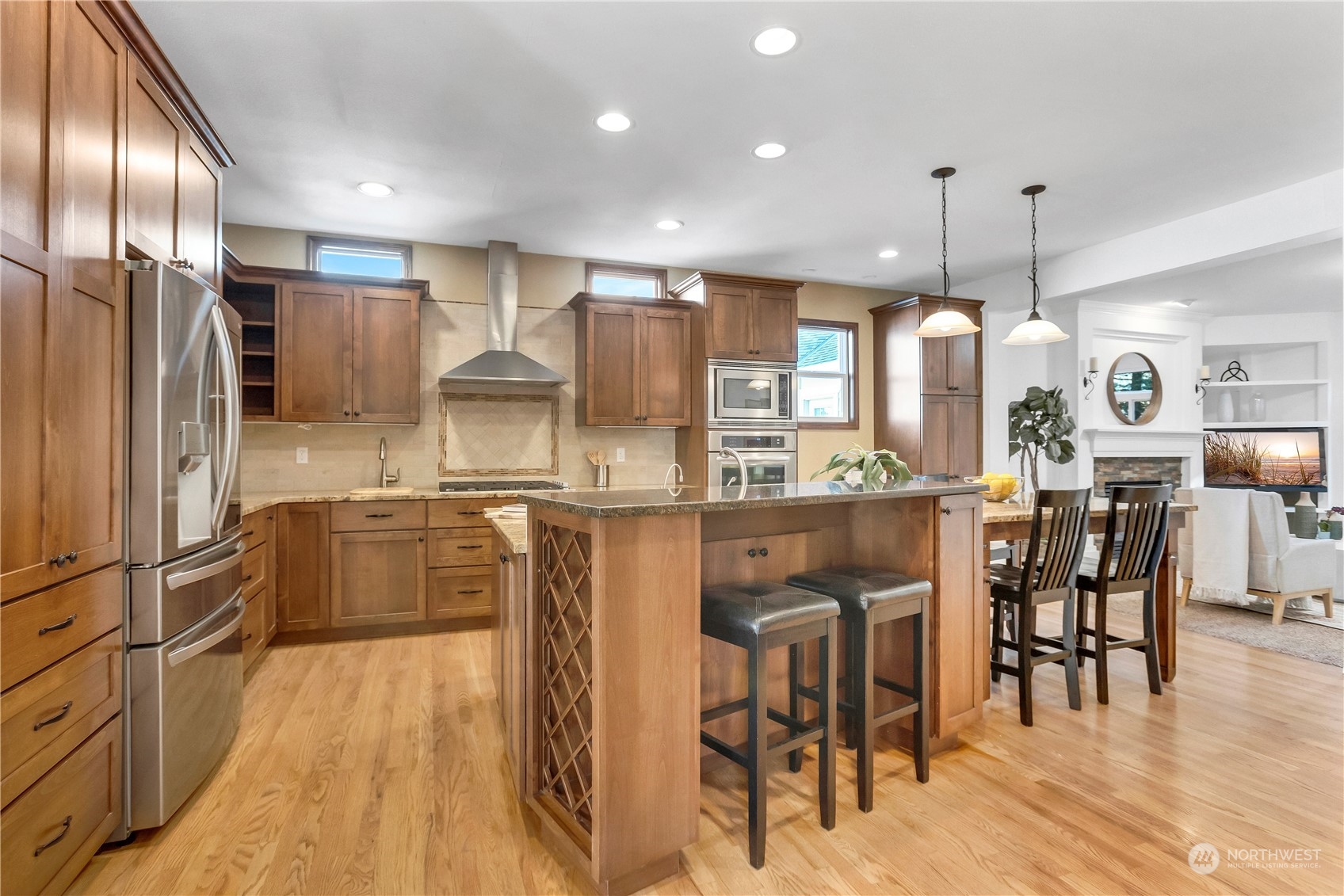 3210 187th Place Southeast Bothell, WA 98012 - Photo 7 of 39 a kitchen with stainless steel appliances kitchen island granite countertop a refrigerator a stove and a wooden floors