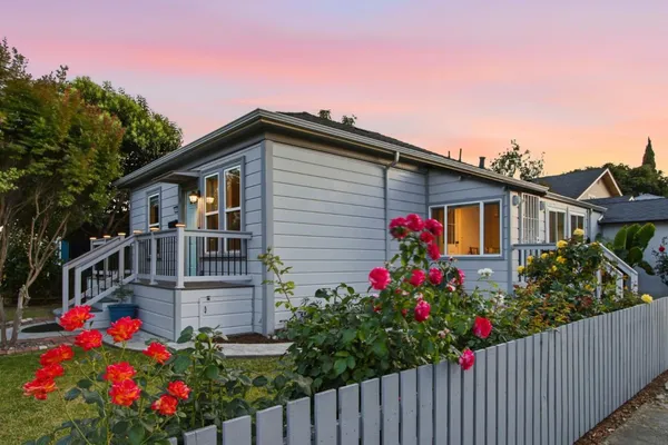 a front view of house and yard with beautiful flowers