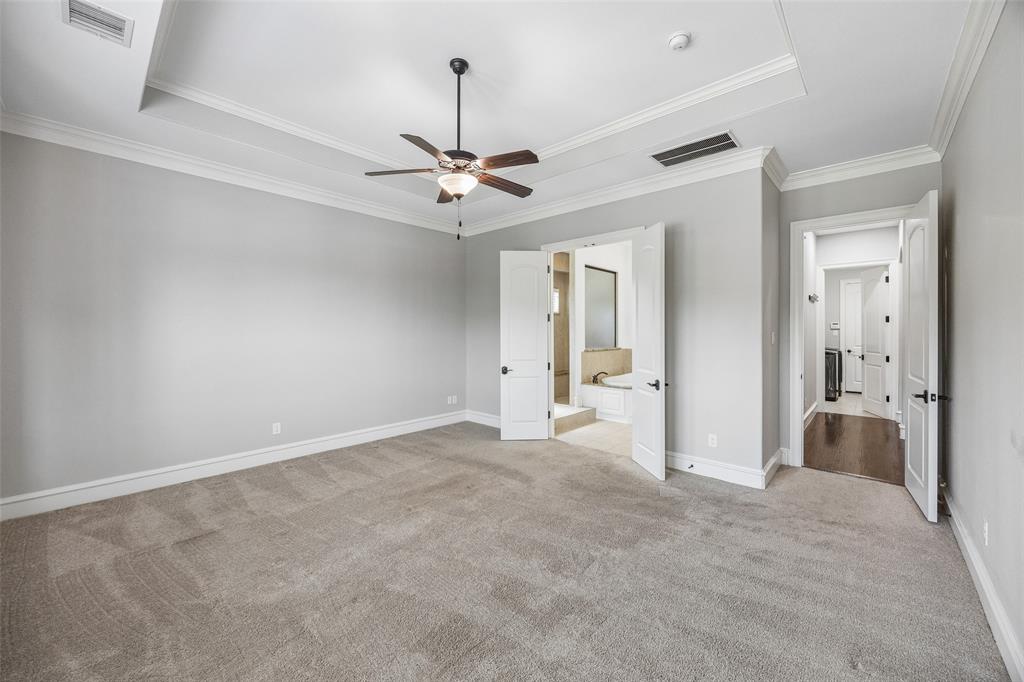134 Santa Rosa Way Irving, TX 75062 - Photo 13 of 26 Spacious primary suite featuring a tray ceiling, abundant natural light, and a serene retreat-like feel.