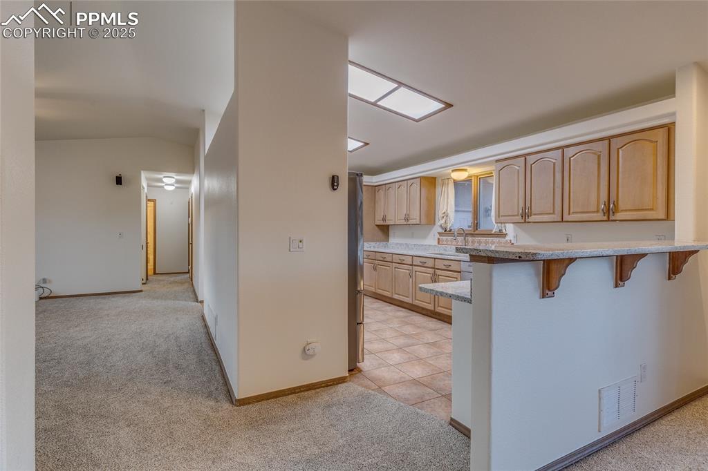 7501 Tudor Road Colorado Springs, CO 80919 - Photo 12 of 48 Kitchen with breakfast bar/new granite countertops to the right and living room on the left