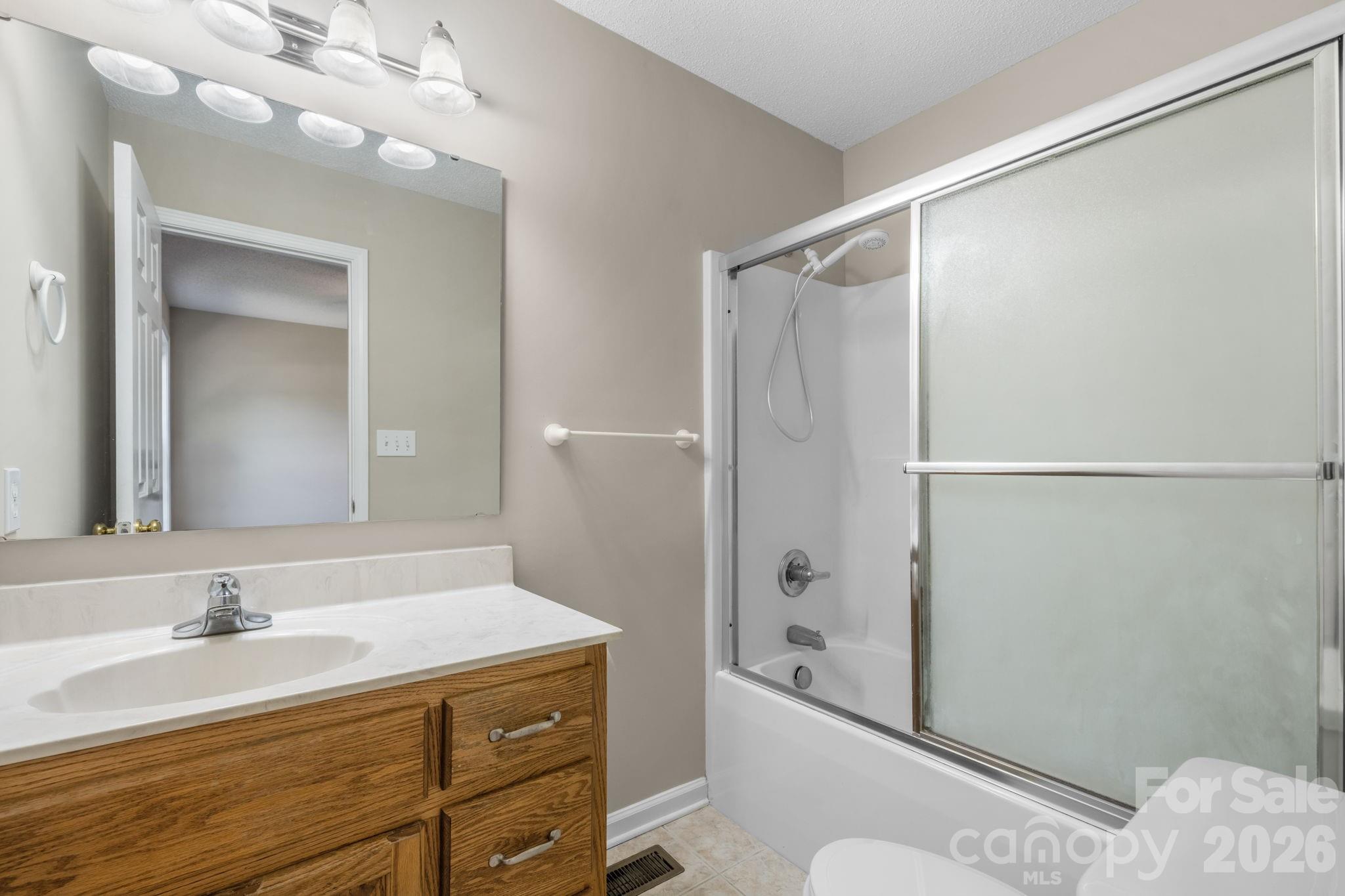 4967 Addison Lane Hickory, NC 28601 - Photo 16 of 43 a bathroom with a granite countertop sink a toilet and shower