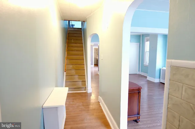 a view of a hallway with wooden floor and stairs