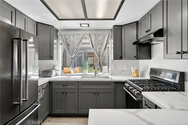 a kitchen with stainless steel appliances granite countertop a sink stove and refrigerator