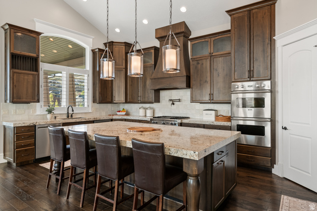 1205 North Elk Rdg Lane, Unit 202 Alpine, UT 84004 - Photo 19 of 88 Gourmet kitchen featuring a large central island with seating, dark wood cabinetry, stainless steel double ovens, and wood-finish flooring