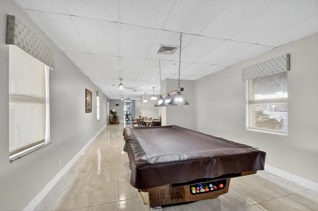a living room with stainless steel appliances furniture a chandelier and a view of kitchen