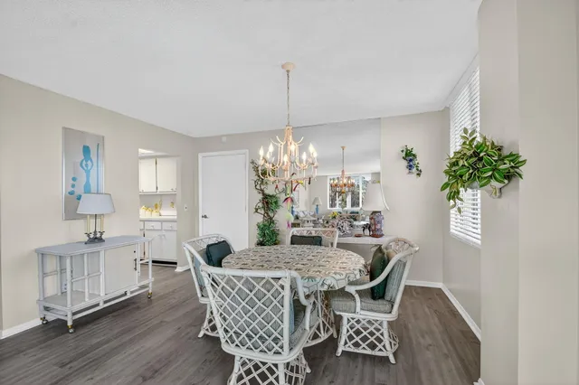 a dining room with furniture potted plants and wooden floor