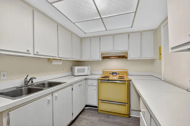 a kitchen with a sink a stove and cabinets