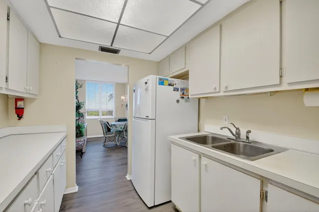 a kitchen with sink a refrigerator and cabinets