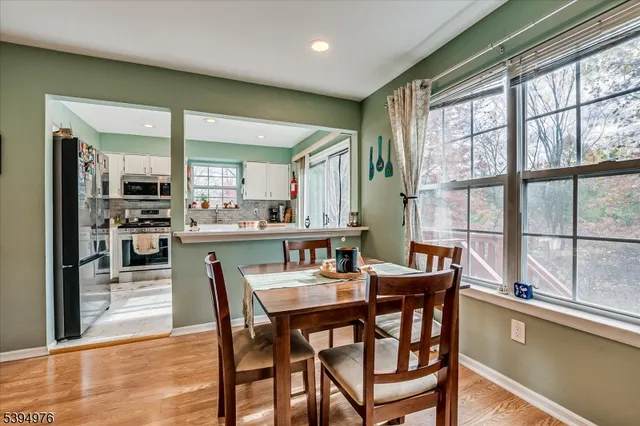 a kitchen with stainless steel appliances granite countertop a stove top oven a sink dishwasher a refrigerator and cabinets with wooden floor