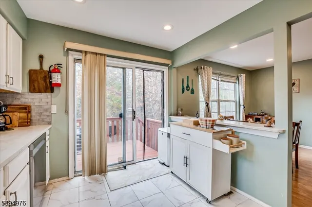 a kitchen with white cabinets and sink