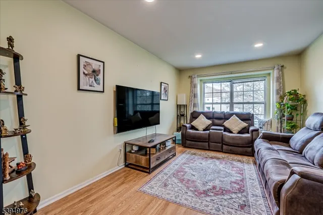 a living room with furniture a flat screen tv and a window