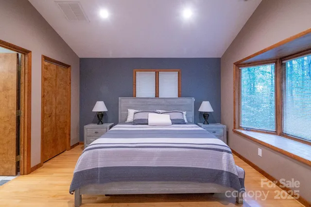 a bedroom with a bed and a large window