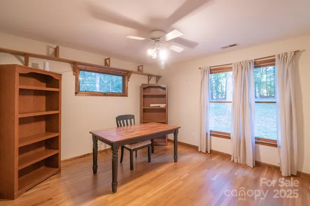 a view of a workspace with furniture and wooden floor