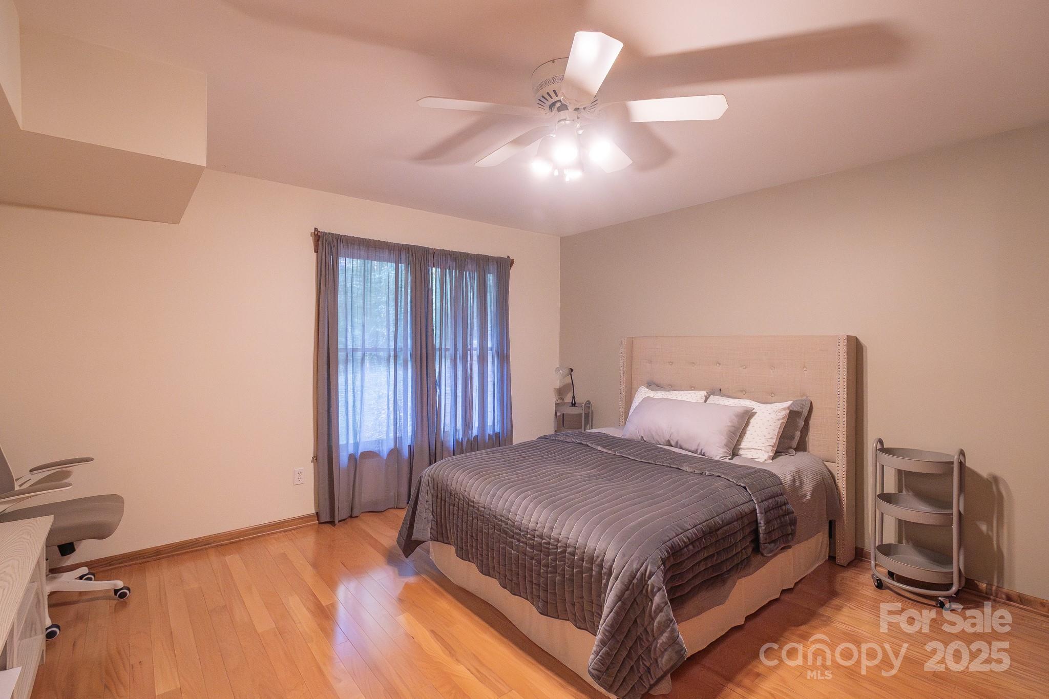 5214 Addison Road Waxhaw, NC 28173 - Photo 21 of 23 a bedroom with a bed and a chandelier