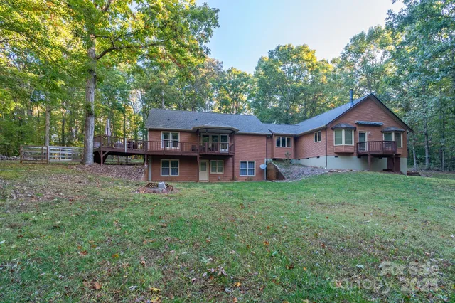 a view of a house with a big yard plants and large trees