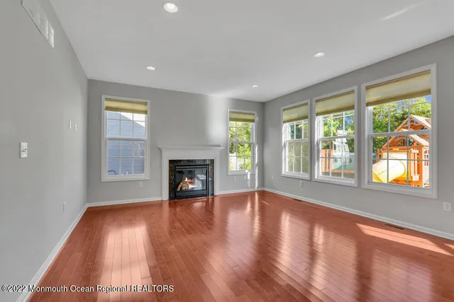 a view of empty room with wooden floor and fireplace