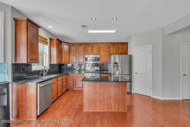a view of an empty room with wooden floor and a fireplace