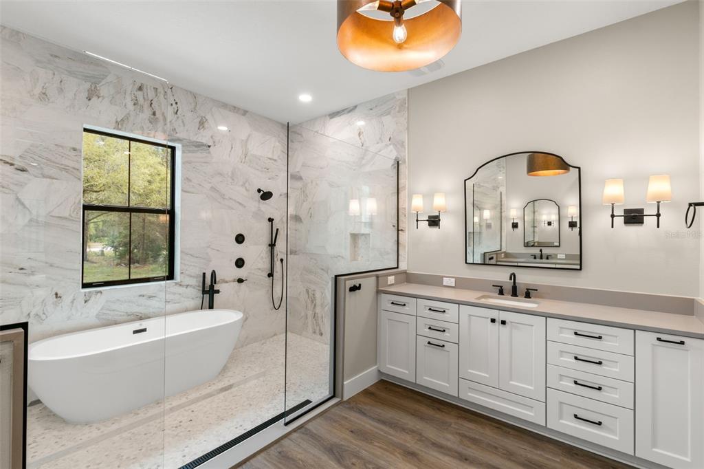 1 Plainview Road, Unit LOT 1 Odessa, FL 33556 - Photo 8 of 16 a spacious bathroom with a double vanity sink a mirror a bathtub and next to a window