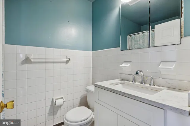a bathroom with a granite countertop sink a toilet and mirror