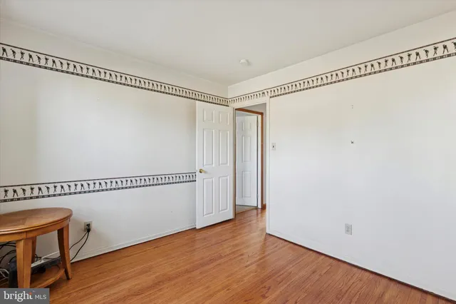 a view of a room with wooden floor and white walls