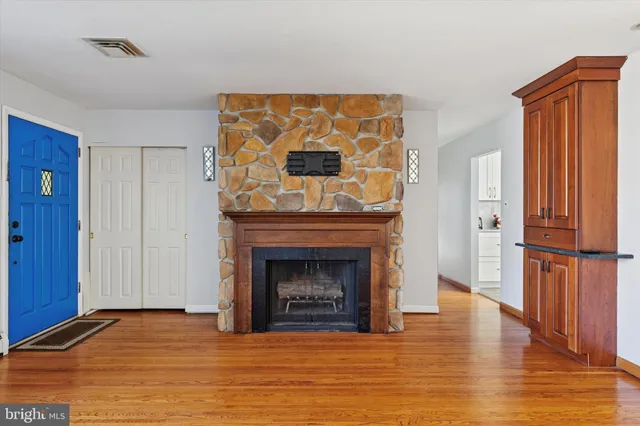 a view of a livingroom with wooden floor and a fireplace