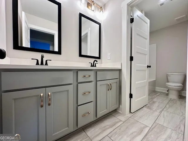 a bathroom with double sink and a mirror