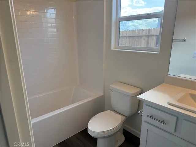 a white toilet sitting next to a bath tub