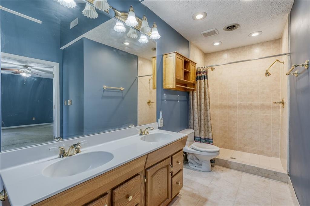 835 Greenvine Trace Roswell, GA 30076 - Photo 14 of 27 a bathroom with a double vanity sink toilet and shower