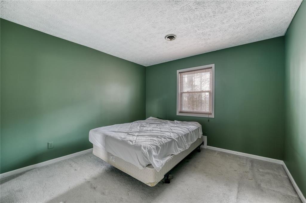 835 Greenvine Trace Roswell, GA 30076 - Photo 17 of 27 a bed sitting in a bedroom next to a window