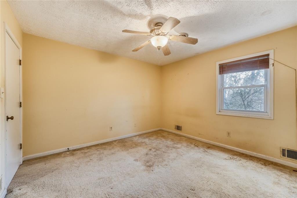 835 Greenvine Trace Roswell, GA 30076 - Photo 18 of 27 an empty room with a chandelier fan and windows