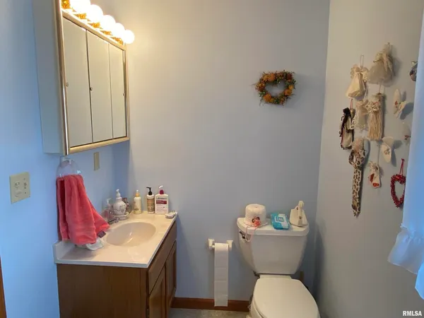 a bathroom with a toilet sink and mirror