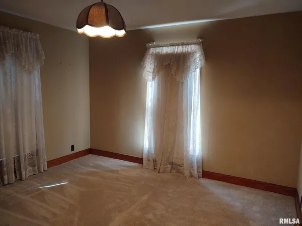 an empty room with windows and chandelier fan