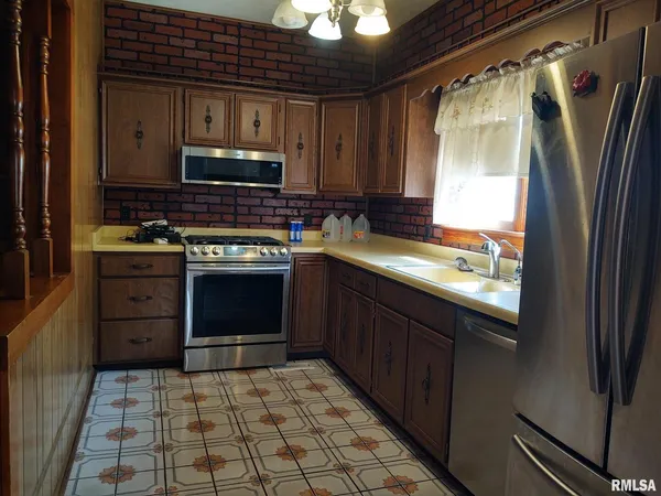 a kitchen with stainless steel appliances granite countertop a stove a sink and a refrigerator