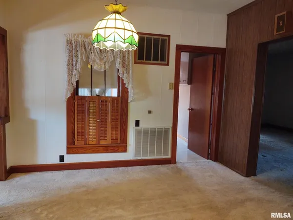 an empty room with wooden floor mirror and windows